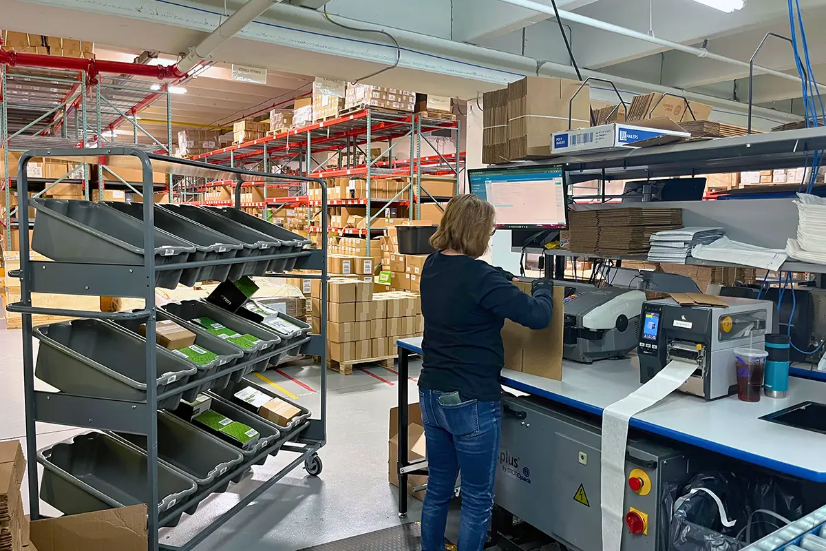 Warehouse worker printing shipping labels at fulfillment station