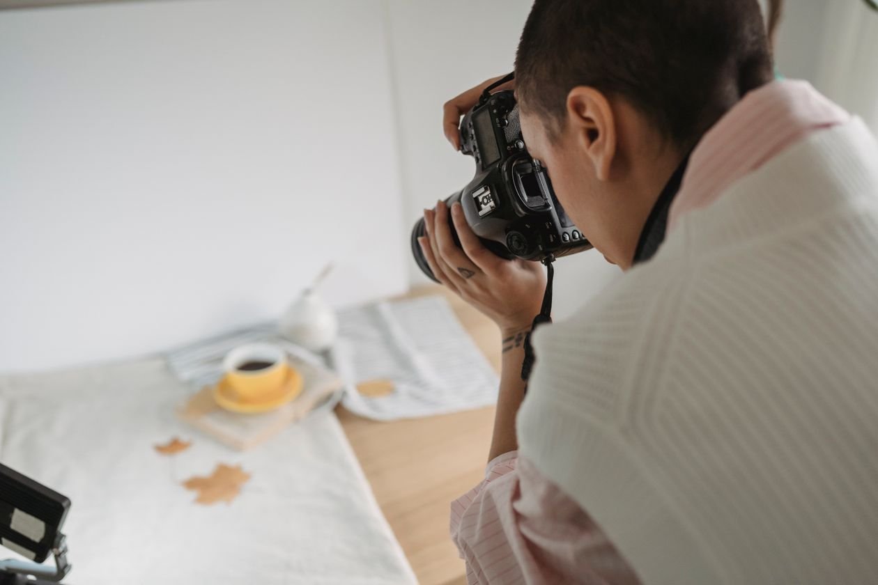 Photographer capturing a styled product scene with a camera
